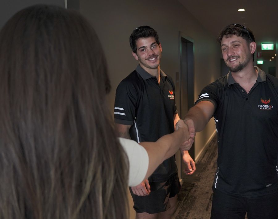 Smiling Phoenix movers shaking hands with a happy customer